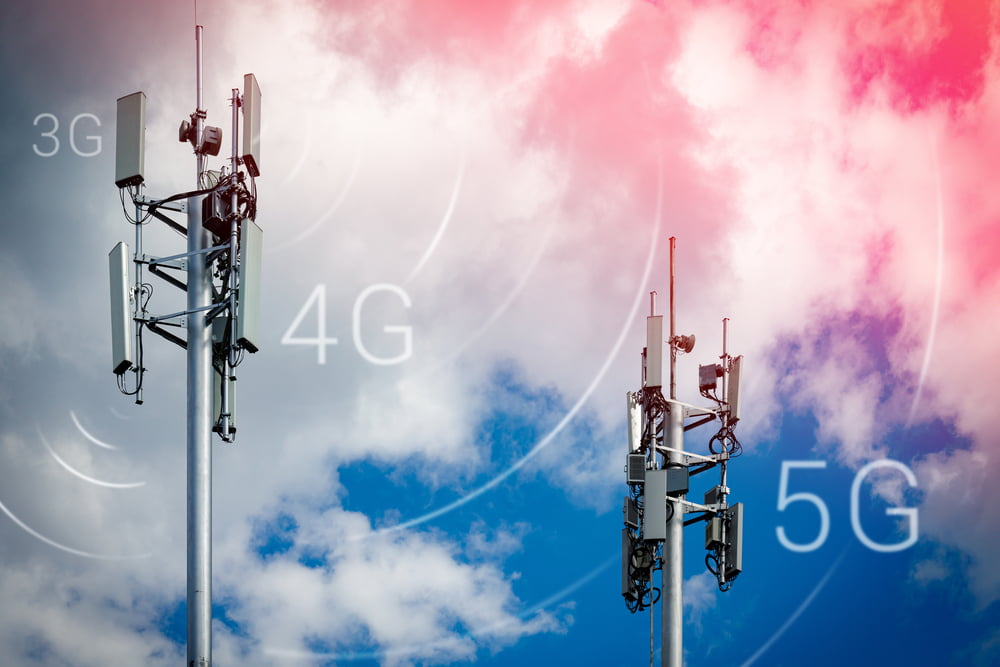 Two telecommunications towers against a sky backdrop, showing 3g, 4g and 5g networks