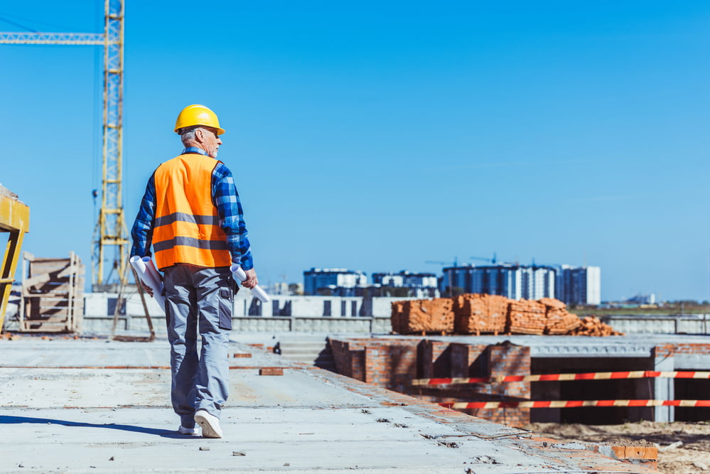 A construction manager walks through a construction site, considering the benefits of telematics