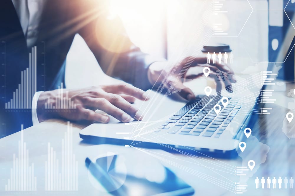 A conceptual image of a businessman and laptop overlaid with graphics to show the concept of cold chain temperature monitoring and management