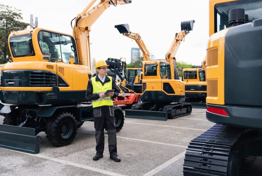 A field technician inspects construction equipment, leveraging integrated telematics to monitor performance and streamline maintenance