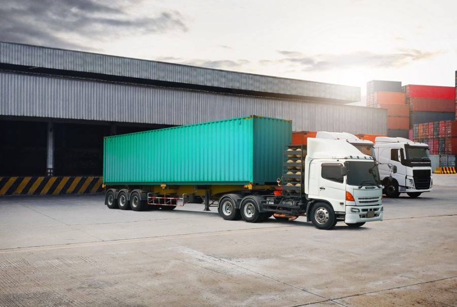 Freight trucks at a logistics hub, showcasing the role of telematics technology in streamlining transport and supply chain operations.