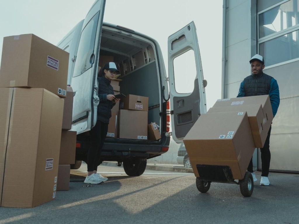 Two delivery people beside a van, highlighting the question: How do I turn fleet telematics data into actionable insights?