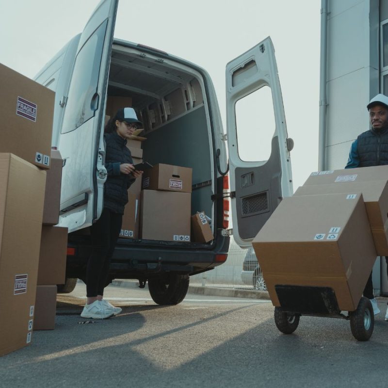 Two delivery people beside a van, highlighting the question: How do I turn fleet telematics data into actionable insights?