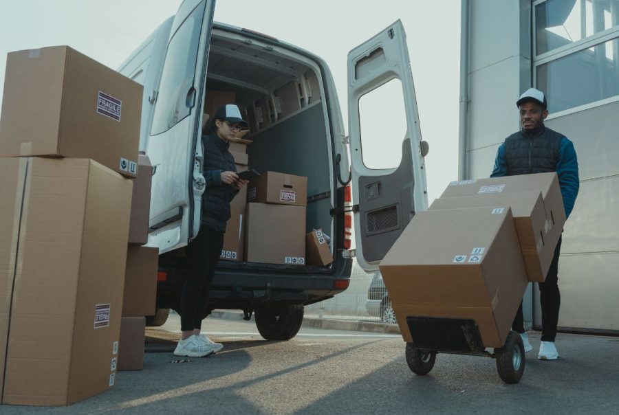 Two delivery people beside a van, highlighting the question: How do I turn fleet telematics data into actionable insights?