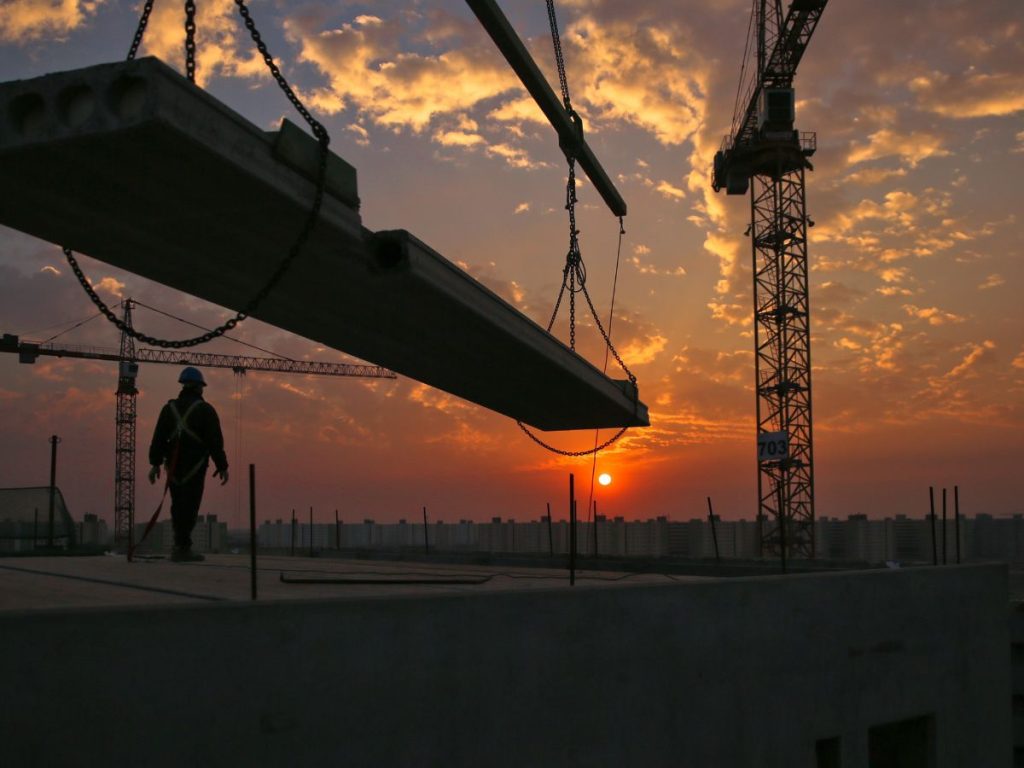 Telematics can improve efficiency on construction sites, such as this large construction site with a crane at sunset