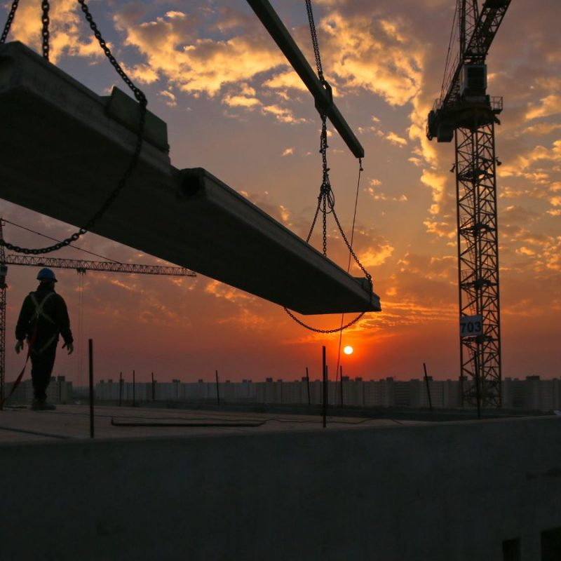 Telematics can improve efficiency on construction sites, such as this large construction site with a crane at sunset