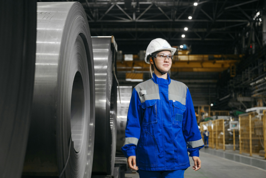 A factory manager in protective clothing walks through an industrial facility, considering IoT platform options for improving automation and operational efficiency