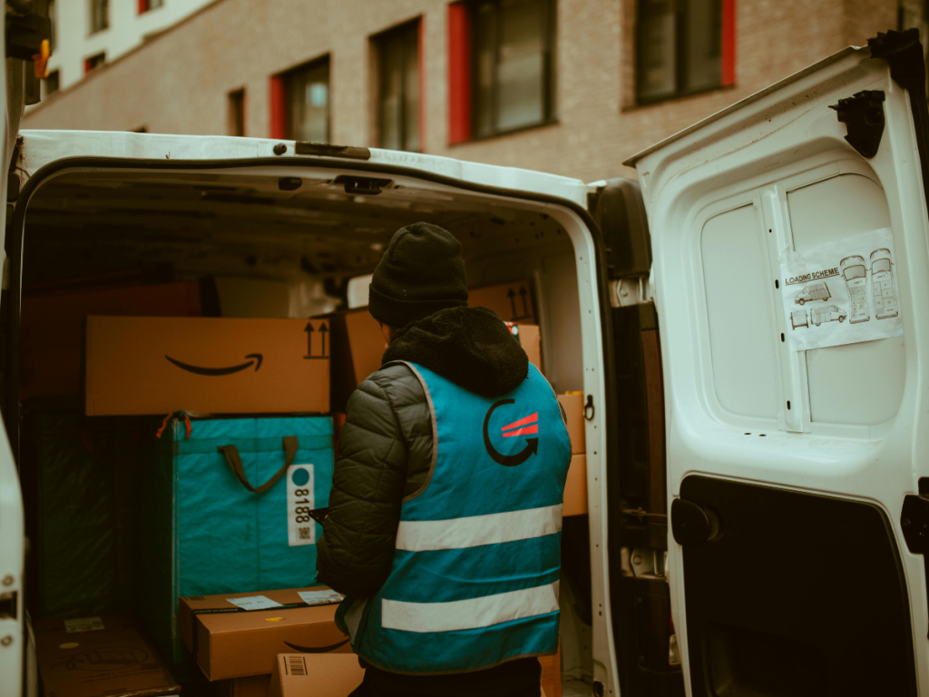 A logistics worker loading parcels into a van, highlighting how IoT platforms like Inauro support device management and real-time operational workflows