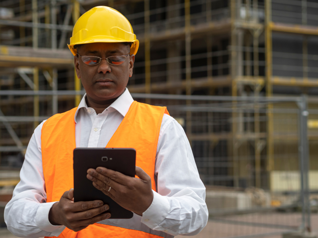 A site manager checks in on the location and status of his assets in front of building works in progress